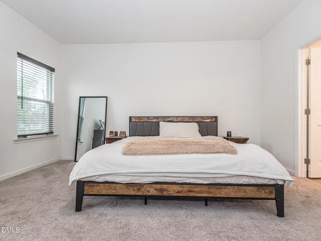 a bedroom with a bed chair and window