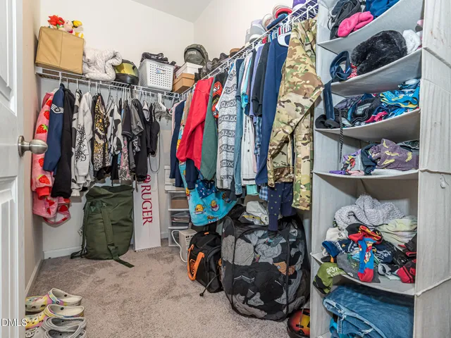 a view of walk in closet with clothes and shoes