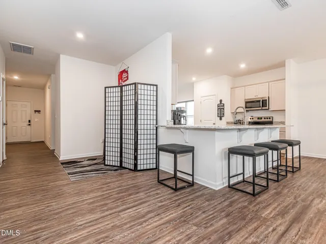 a kitchen with stainless steel appliances granite countertop a refrigerator and a stove top oven