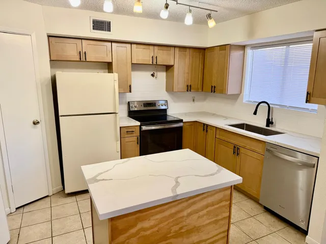 a kitchen with a sink a refrigerator and cabinets
