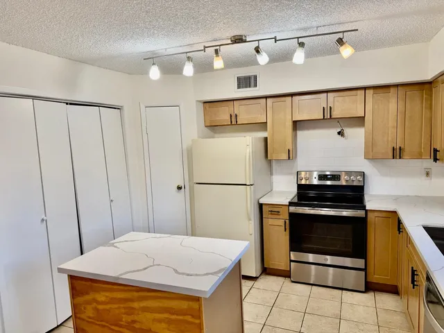a kitchen with stainless steel appliances granite countertop a stove and a refrigerator