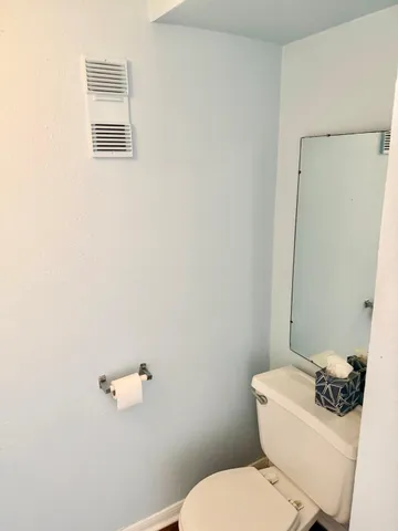 a white toilet sitting next to a bathroom sink
