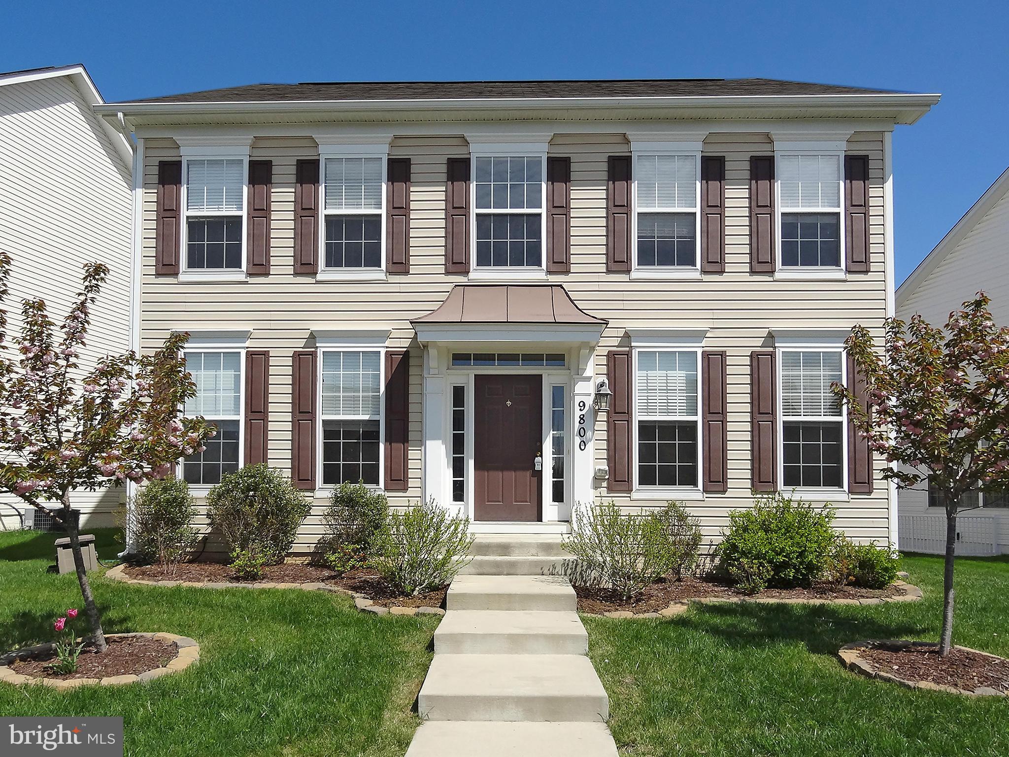 9800 Traver Street Bowie, MD 20721 - Photo 1 of 30 front view of a brick house with a yard garden and large trees
