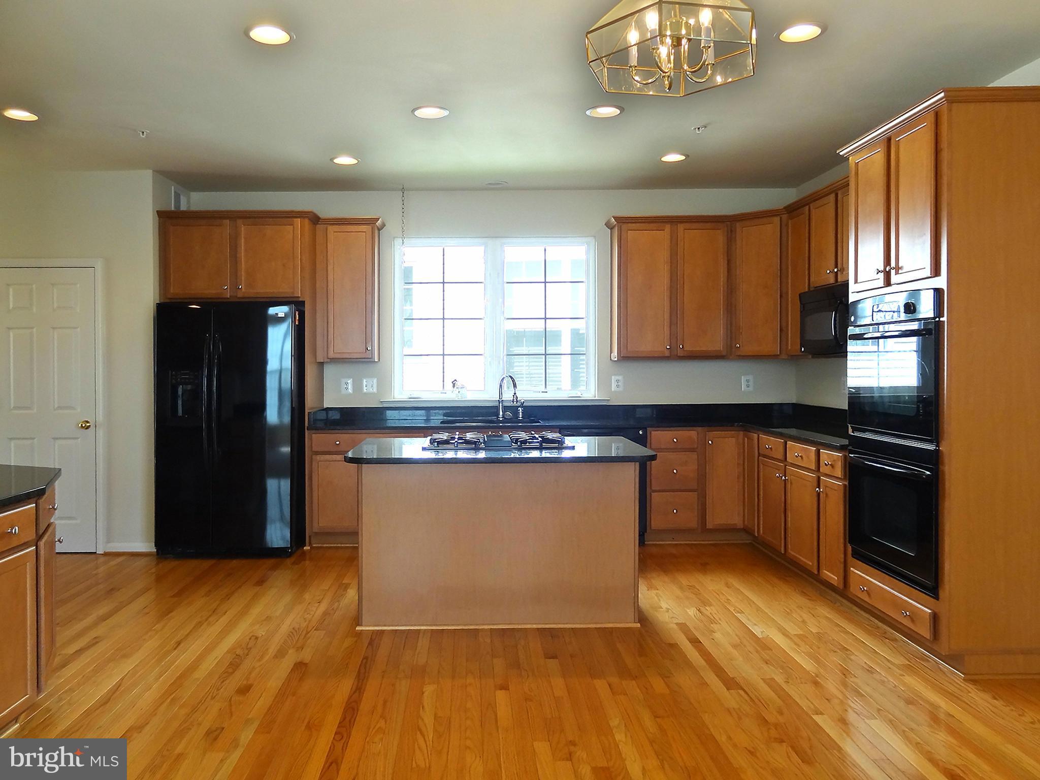 9800 Traver Street Bowie, MD 20721 - Photo 17 of 30 a kitchen with stainless steel appliances granite countertop a refrigerator a sink dishwasher a stove with wooden cabinets and floor