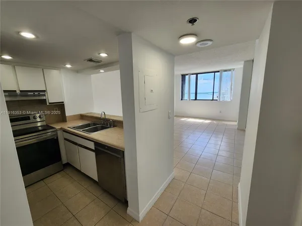 a kitchen with stainless steel appliances wooden floor sink and stove