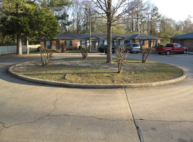 a front view of a house with a yard and trees