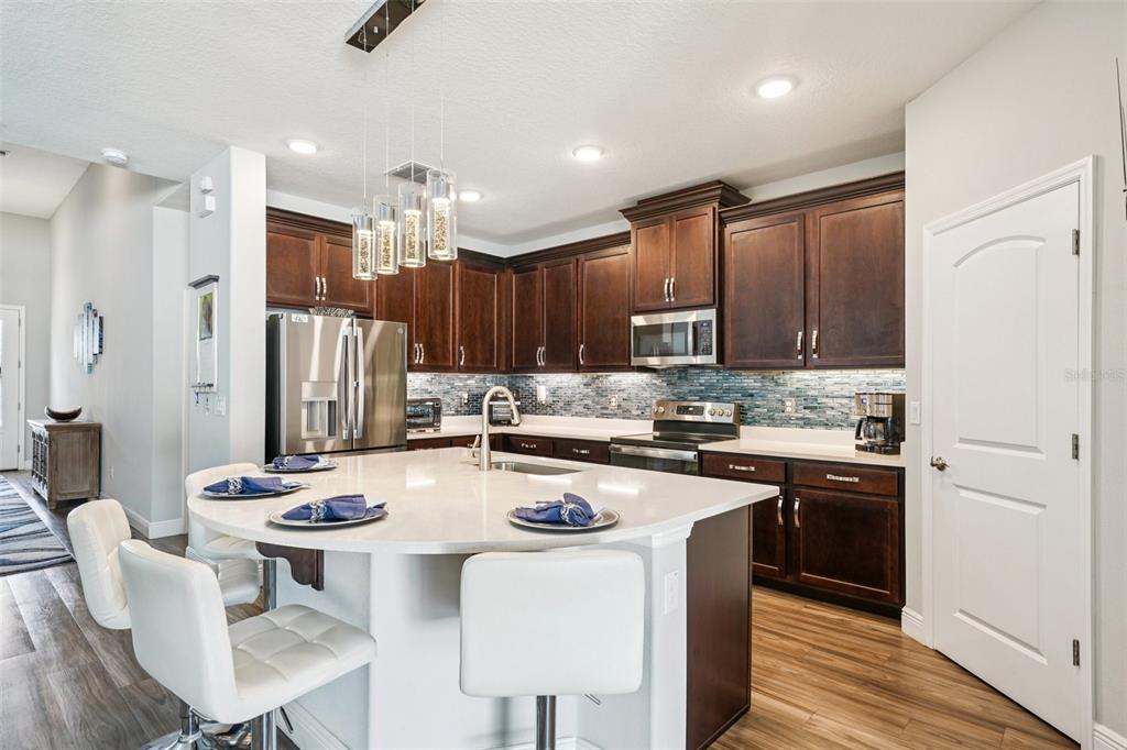 12627 Vander Way New Port Richey, FL 34654 - Photo 20 of 77 a kitchen with kitchen island granite countertop a sink cabinets and stainless steel appliances