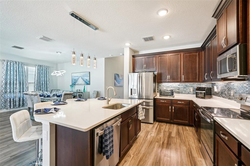 12627 Vander Way New Port Richey, FL 34654 - Photo 21 of 77 a kitchen with sink a stove and cabinets