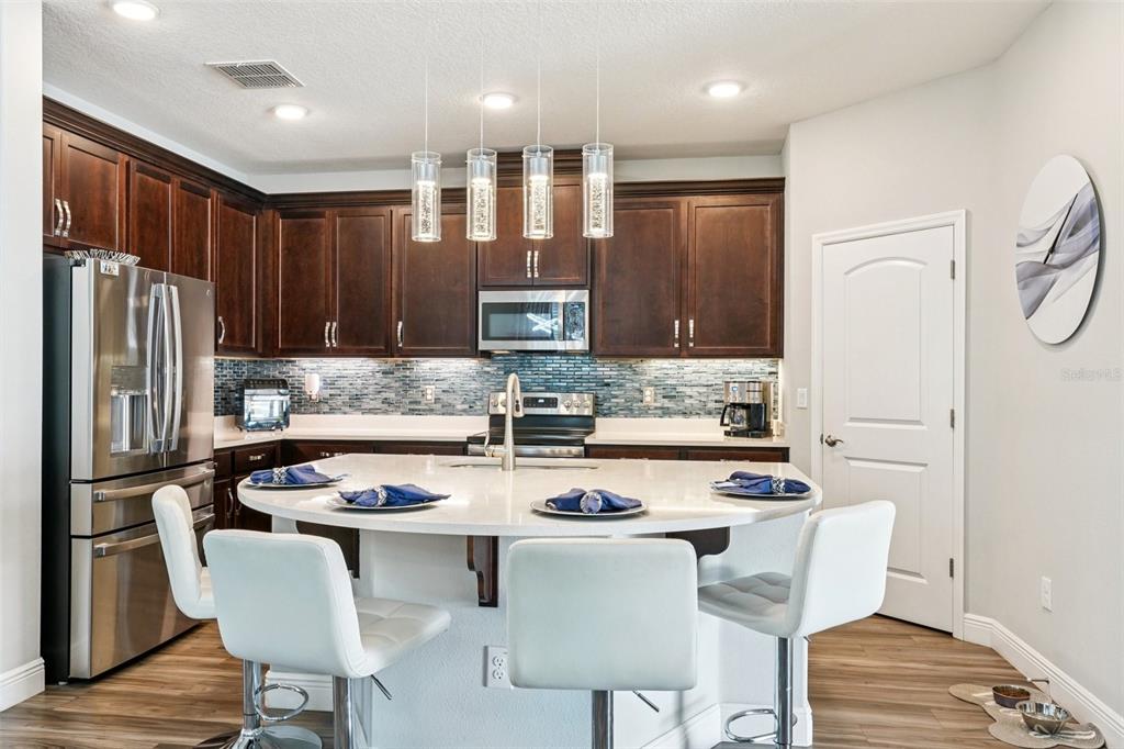 12627 Vander Way New Port Richey, FL 34654 - Photo 27 of 77 a kitchen with stainless steel appliances granite countertop a stove a sink a refrigerator white cabinets and wooden floor