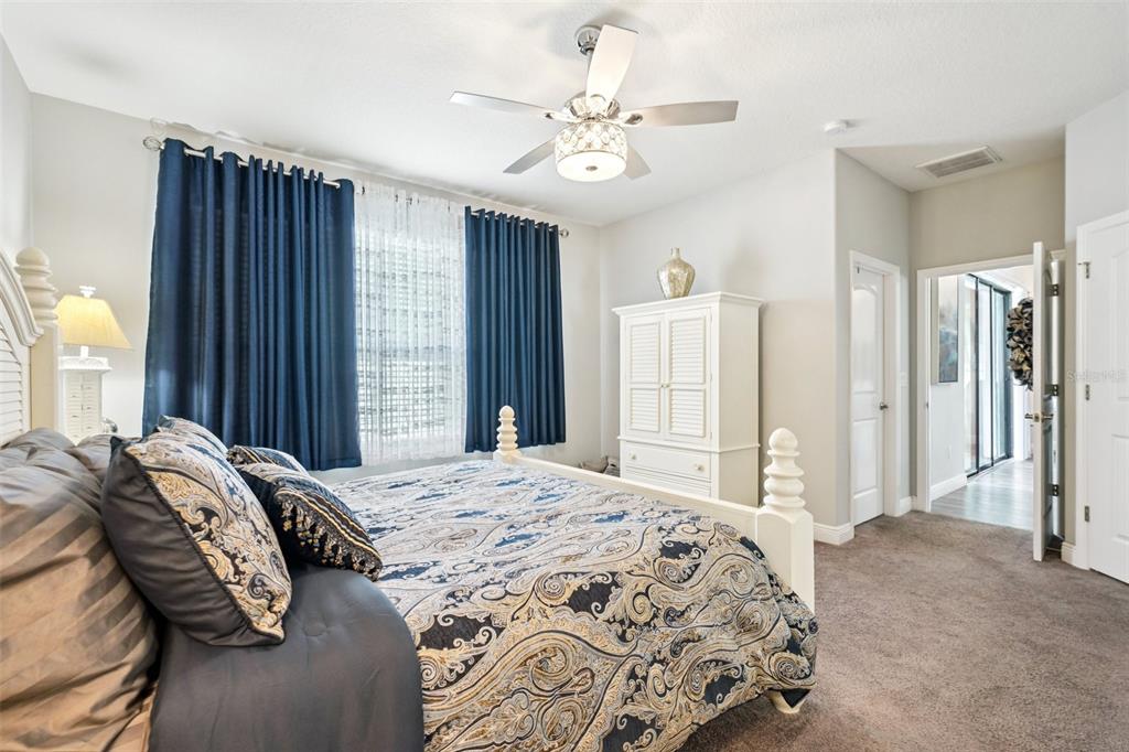 12627 Vander Way New Port Richey, FL 34654 - Photo 47 of 77 a bedroom with a large bed and a chandelier