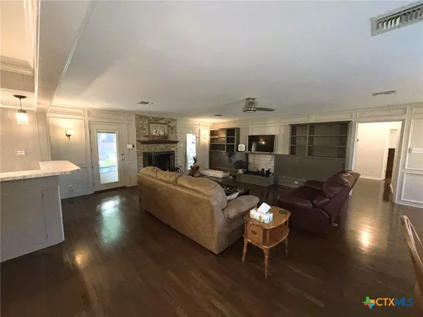 a living room with fireplace furniture and a large window