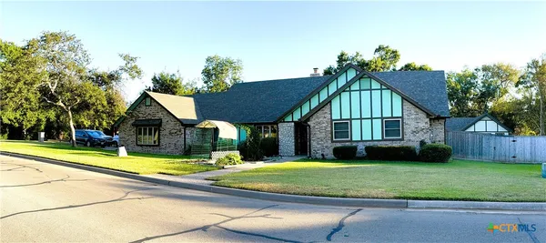a view of swimming pool with lawn chairs and plants
