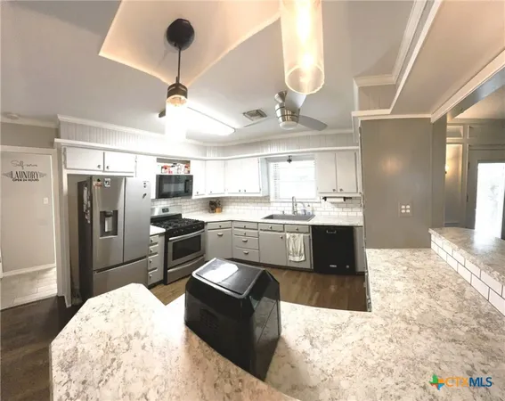 a large kitchen with kitchen island a sink stainless steel appliances and cabinets
