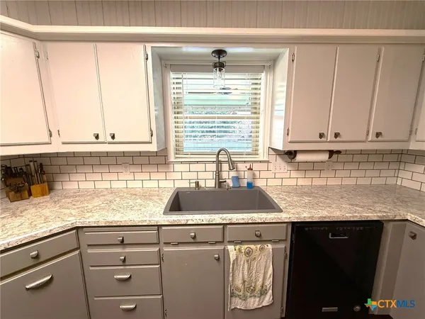 a kitchen with stainless steel appliances granite countertop a refrigerator a oven a sink a dining table and chairs with wooden floor