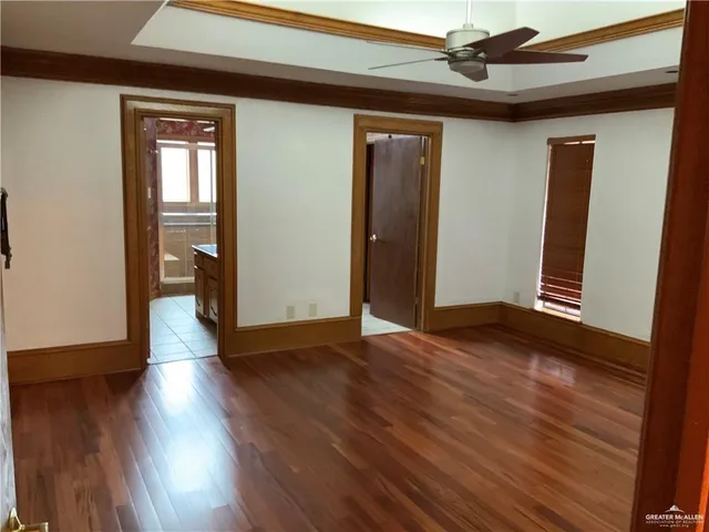 a view of empty room with wooden floor