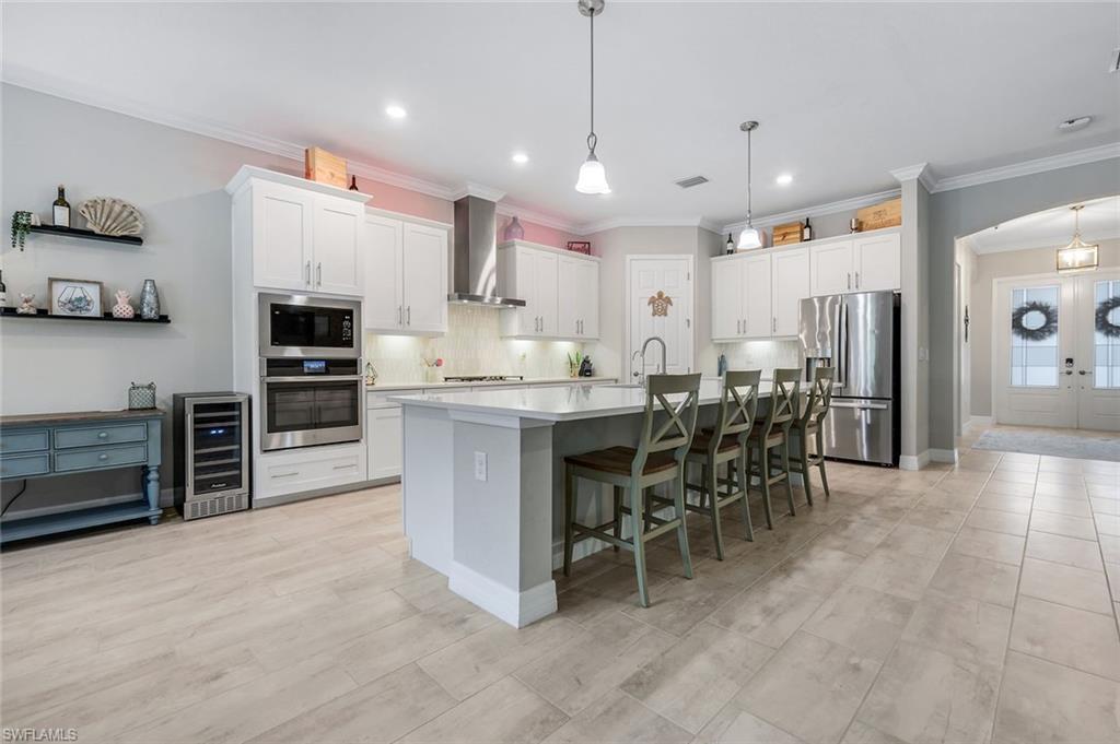 14841 Blue Bay Circle Fort Myers, FL 33913 - Photo 12 of 47 a large kitchen with cabinets chairs and stainless steel appliances