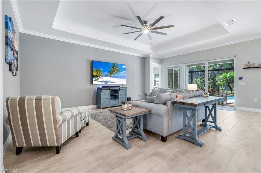 14841 Blue Bay Circle Fort Myers, FL 33913 - Photo 7 of 47 a living room with furniture a clock on the desk and a flat screen tv