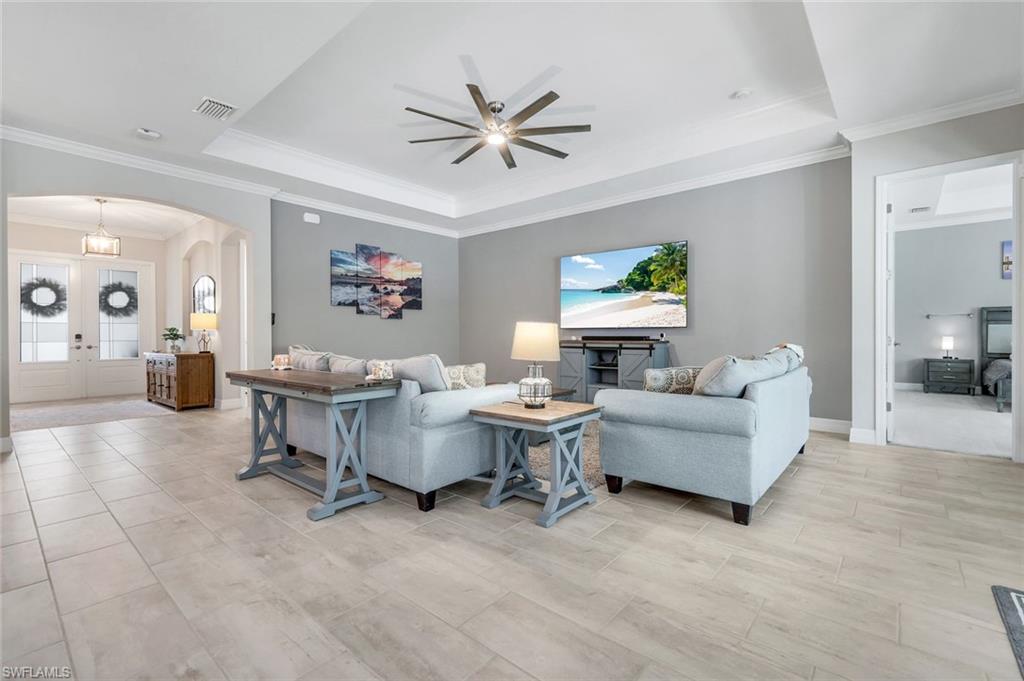 14841 Blue Bay Circle Fort Myers, FL 33913 - Photo 10 of 47 a living room with couches a fireplace and a dining table with wooden floor