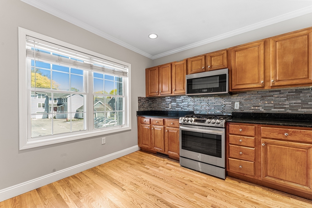 60 Dodge Street, Unit 3 Beverly, MA 01915 - Photo 6 of 30 a kitchen with stainless steel appliances granite countertop a stove a sink and a microwave