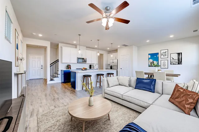 a living room with furniture kitchen view and a dining table