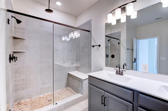a bathroom with a shower sink and mirror