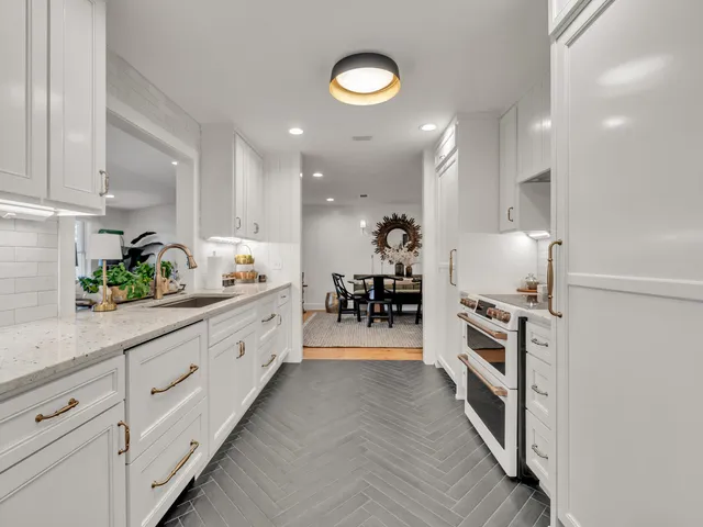 a kitchen with granite countertop white cabinets and stainless steel appliances