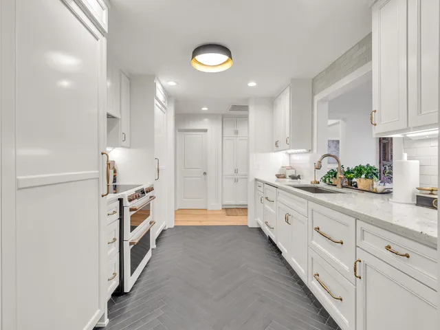 a kitchen with white cabinets and sink
