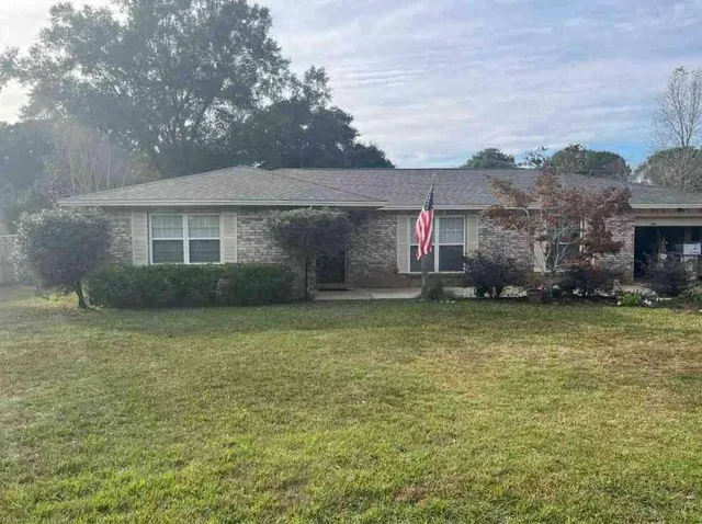 a front view of a house with a garden