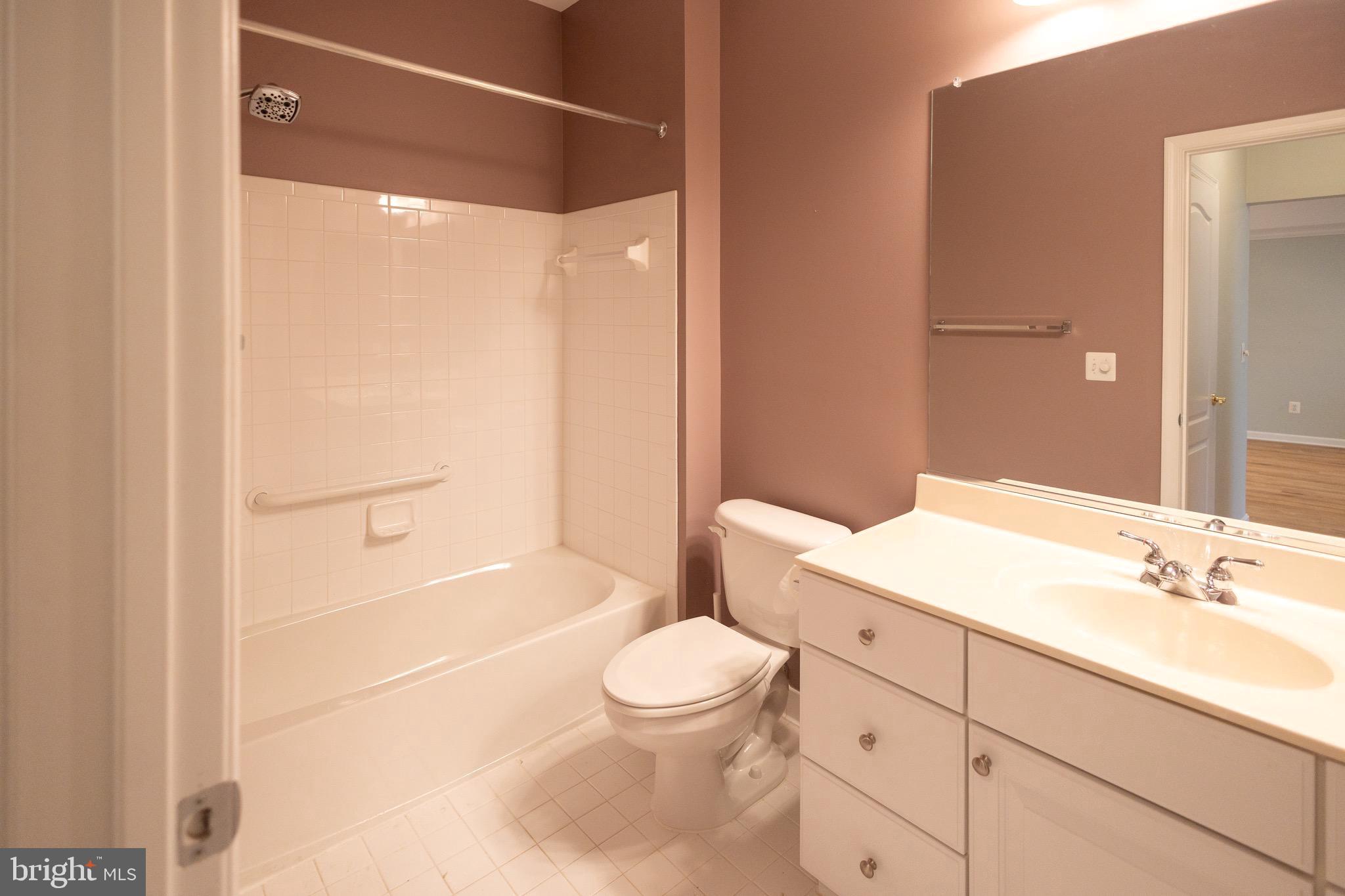 8612 Fluttering Leaf Trail, Unit 404 Odenton, MD 21113 - Photo 13 of 27 a bathroom with a sink a toilet and shower