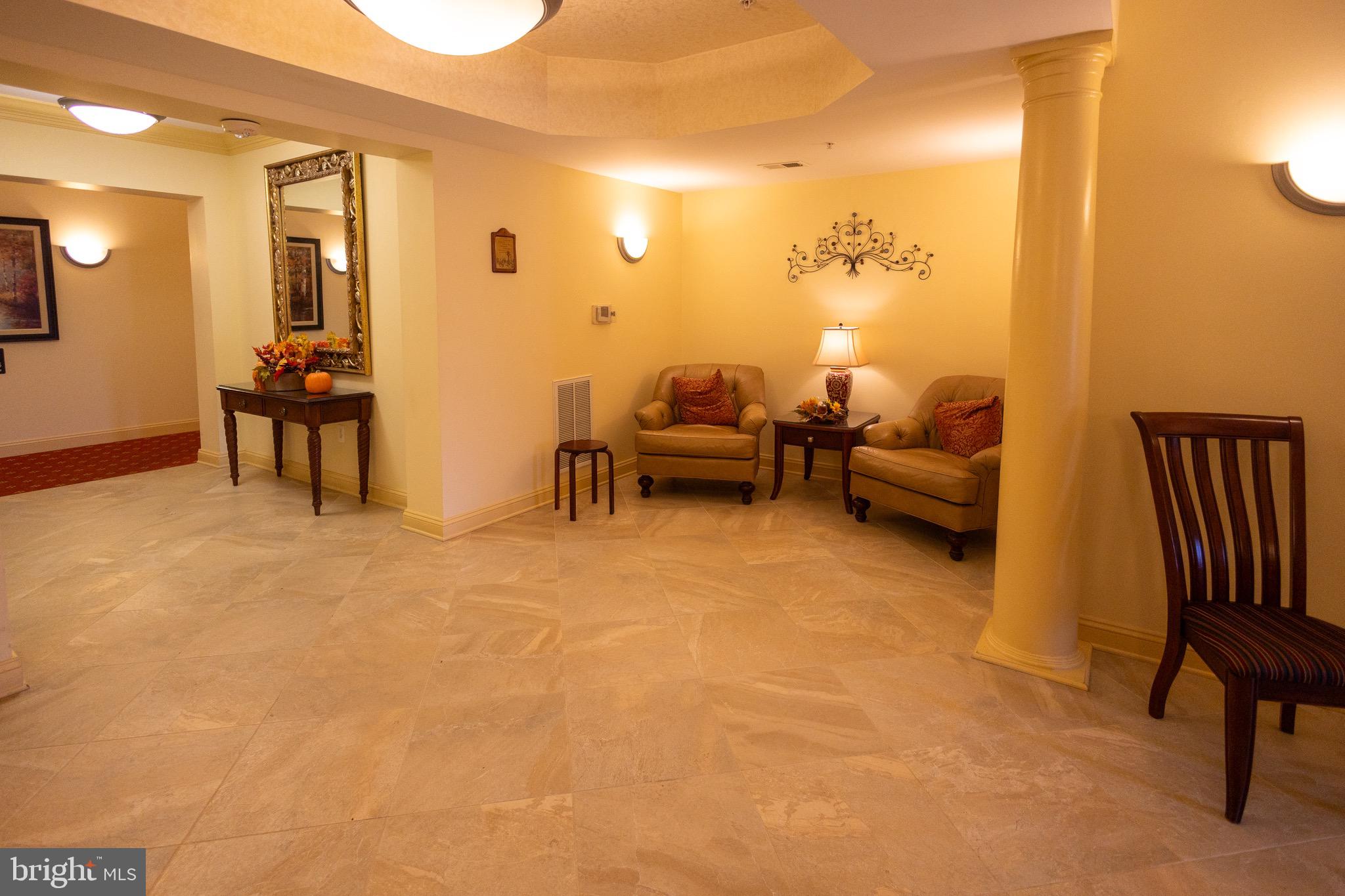 8612 Fluttering Leaf Trail, Unit 404 Odenton, MD 21113 - Photo 23 of 27 a living room with furniture and a lamp