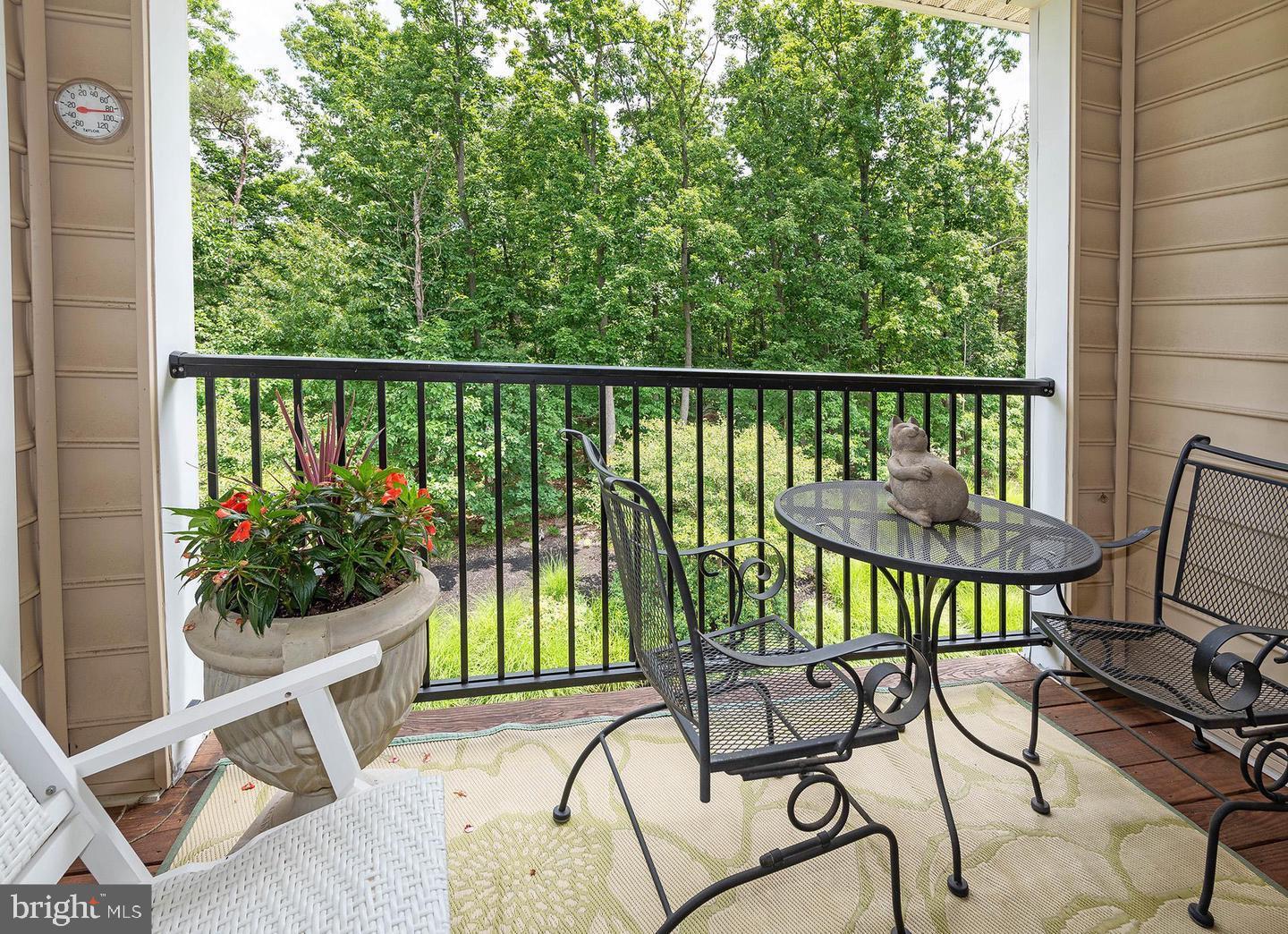 8612 Fluttering Leaf Trail, Unit 404 Odenton, MD 21113 - Photo 24 of 27 a view of a chairs and table in the balcony