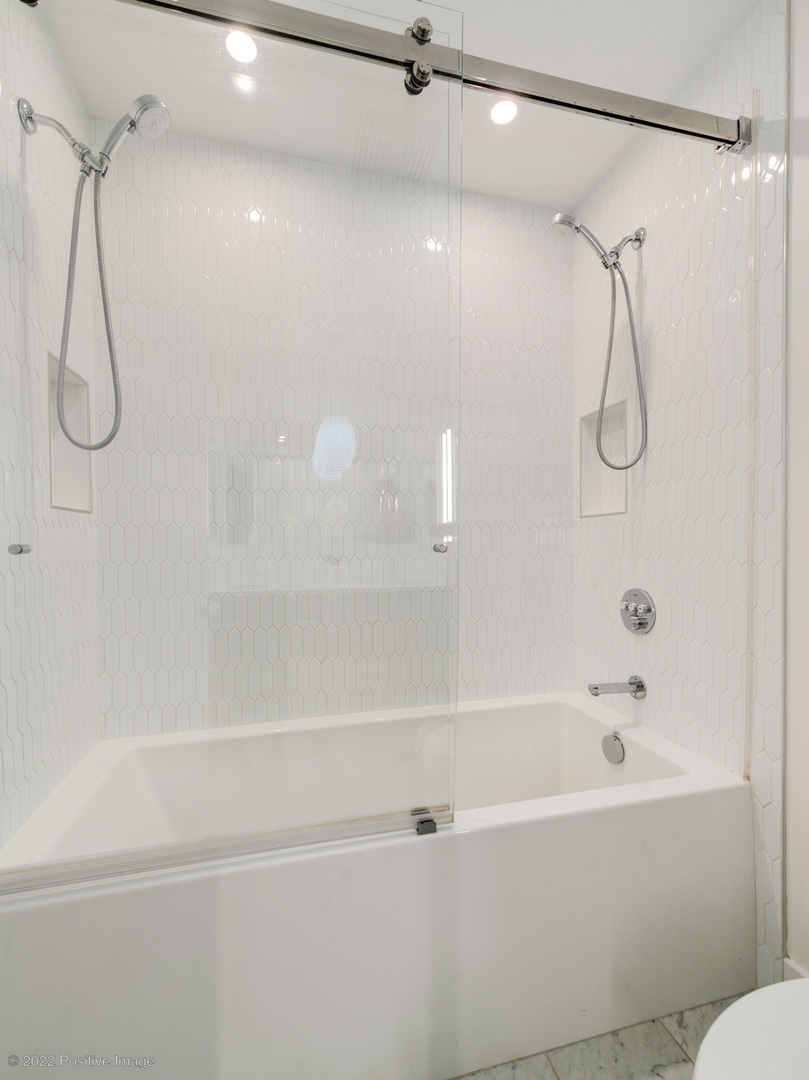 1000 West Adams Street, Unit 613 Chicago, IL 60607 - Photo 11 of 26 a bathroom with a bath tub with a shower