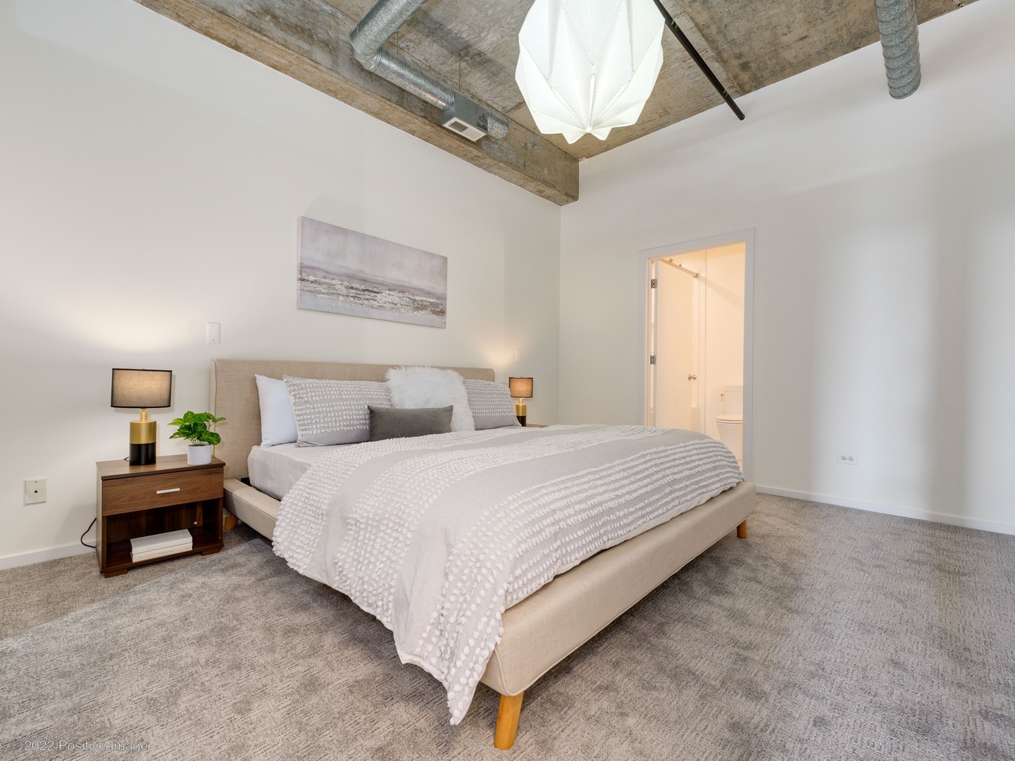 1000 West Adams Street, Unit 613 Chicago, IL 60607 - Photo 13 of 26 a spacious bedroom with a bed and a chandelier