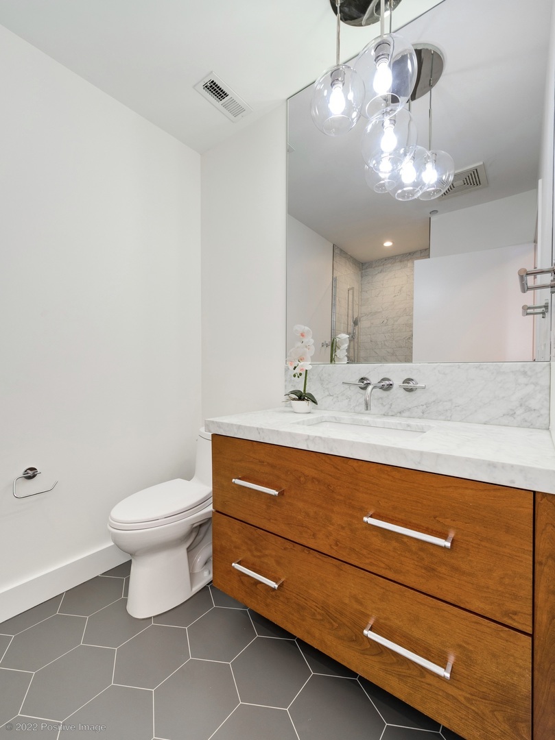 1000 West Adams Street, Unit 613 Chicago, IL 60607 - Photo 15 of 26 a bathroom with a toilet sink and mirror