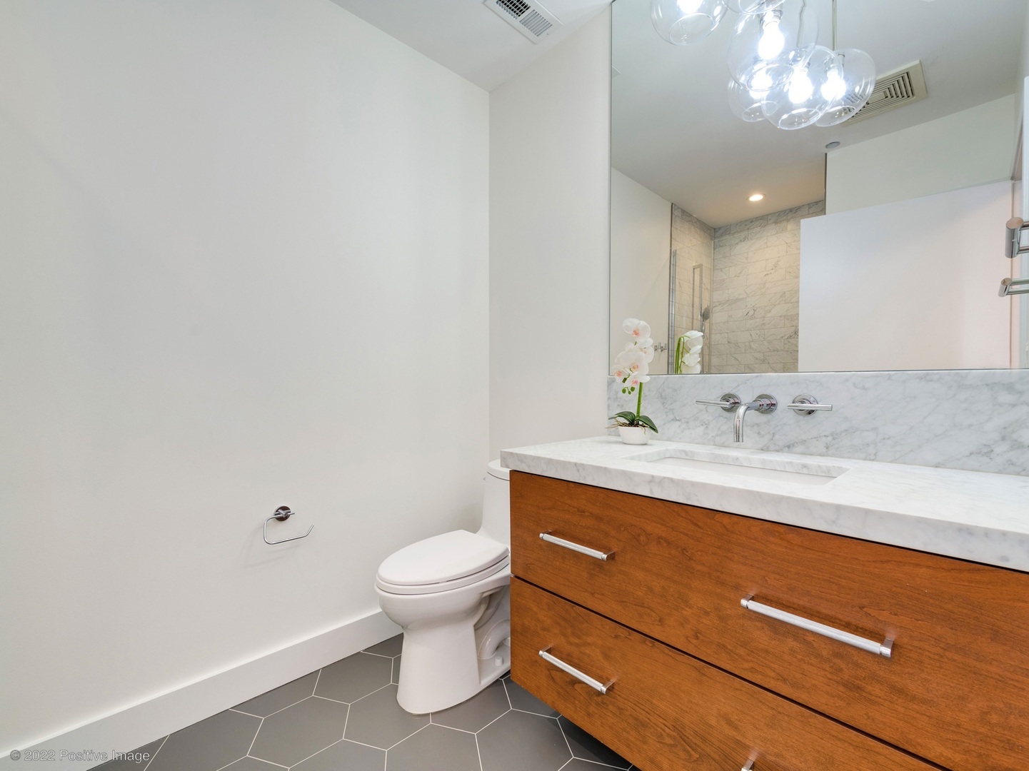 1000 West Adams Street, Unit 613 Chicago, IL 60607 - Photo 17 of 26 a bathroom with a granite countertop sink a toilet and a mirror