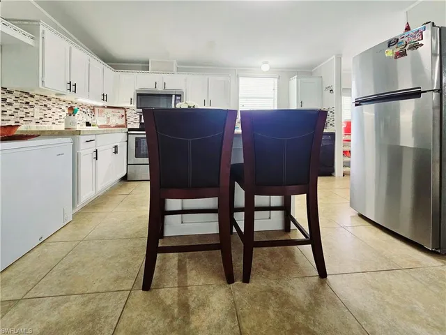 a kitchen with stainless steel appliances granite countertop a sink refrigerator and microwave