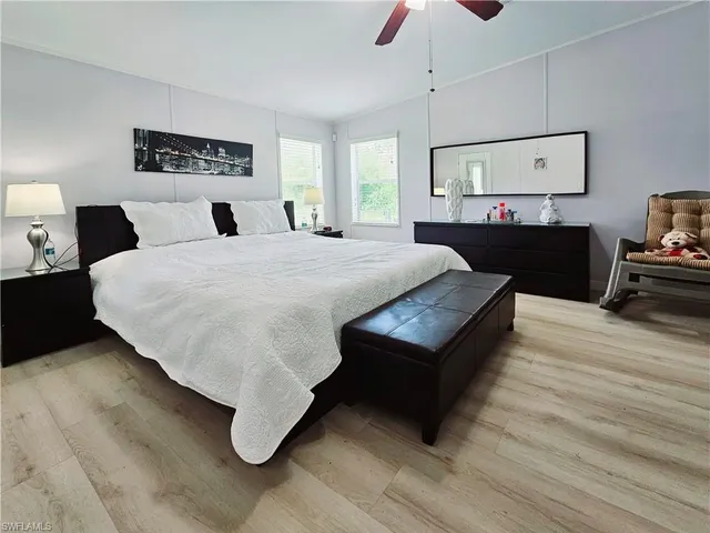 a spacious bedroom with a bed and wooden floor