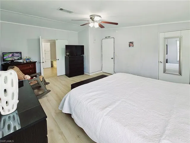 a spacious bedroom with a bed and a chandelier
