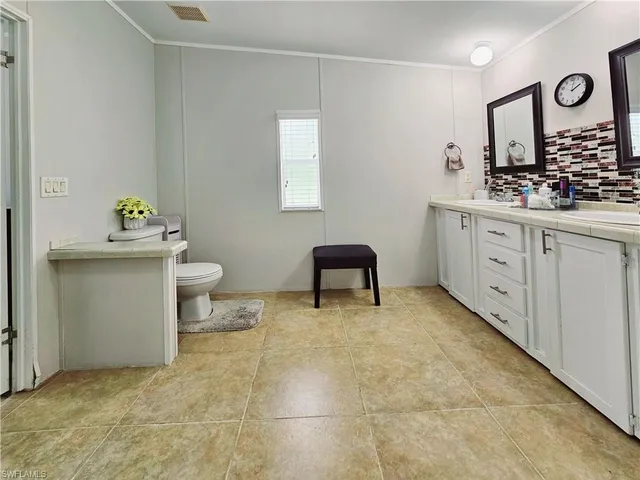 a spacious bathroom with a toilet sink and mirror