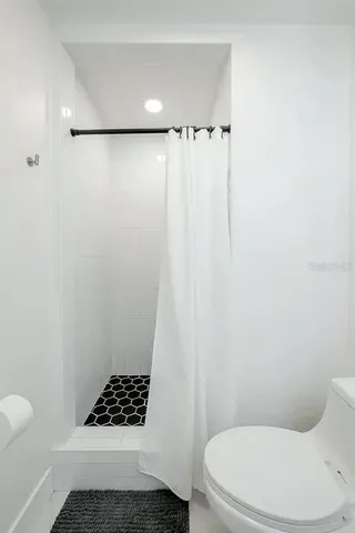 a bathroom with a toilet and a shower curtain