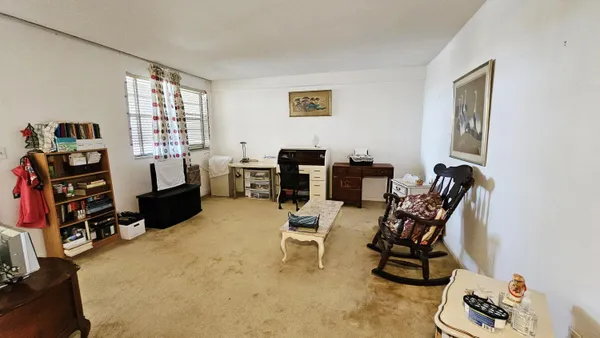 a view of a workspace with furniture and a window
