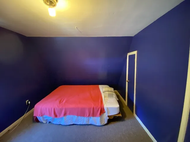 a bed sitting in a room next to a wall