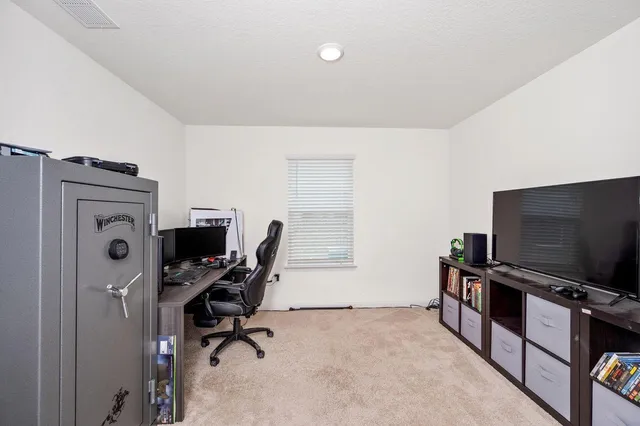 a view of a workspace with furniture and a flat screen tv