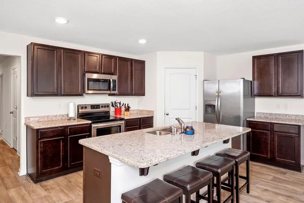 a kitchen with stainless steel appliances granite countertop a stove refrigerator sink and cabinets