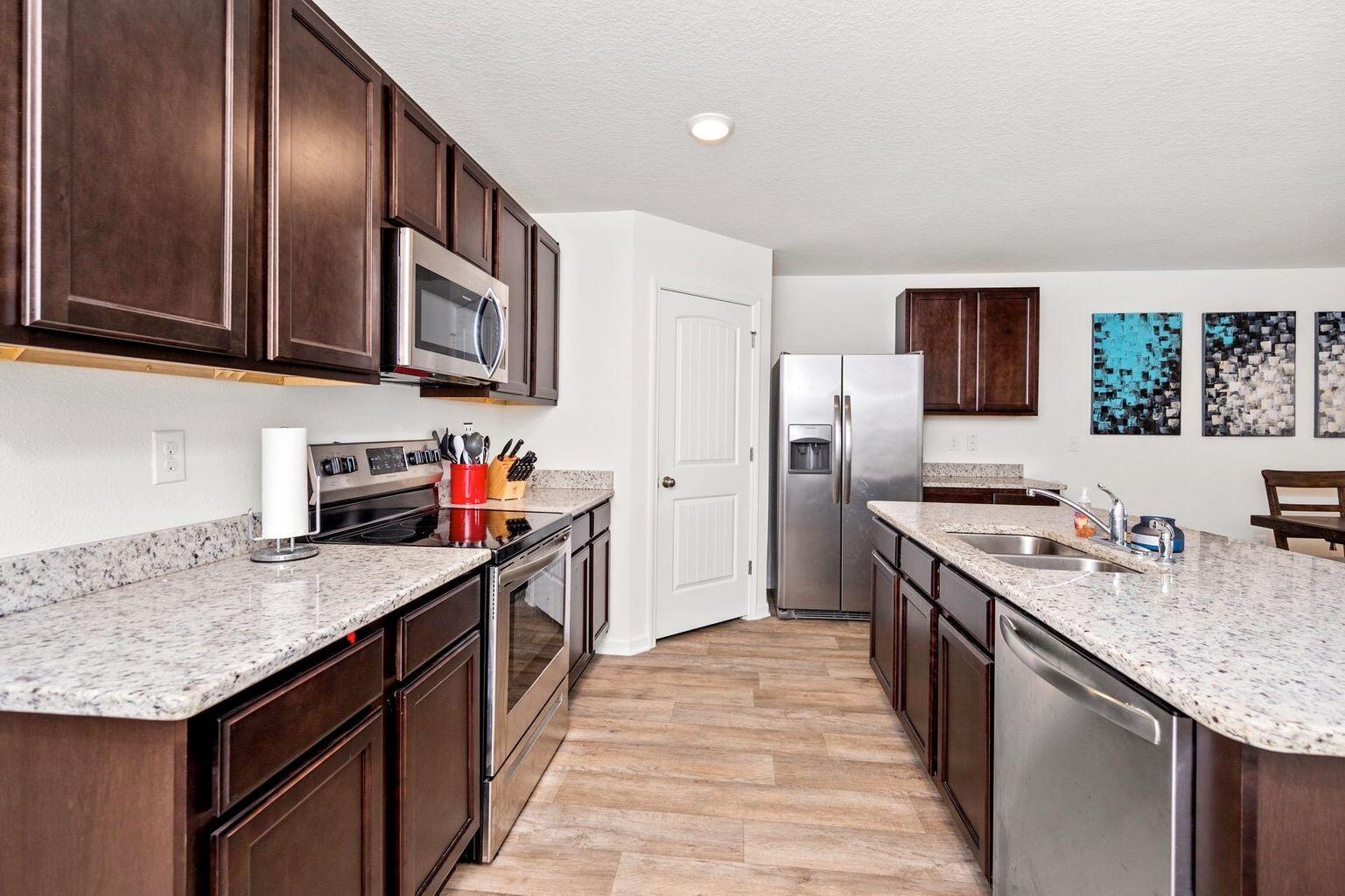 816 Moorhen Way Crestview, FL 32539 - Photo 9 of 19 a kitchen with stainless steel appliances granite countertop a kitchen island a stove a sink and a refrigerator