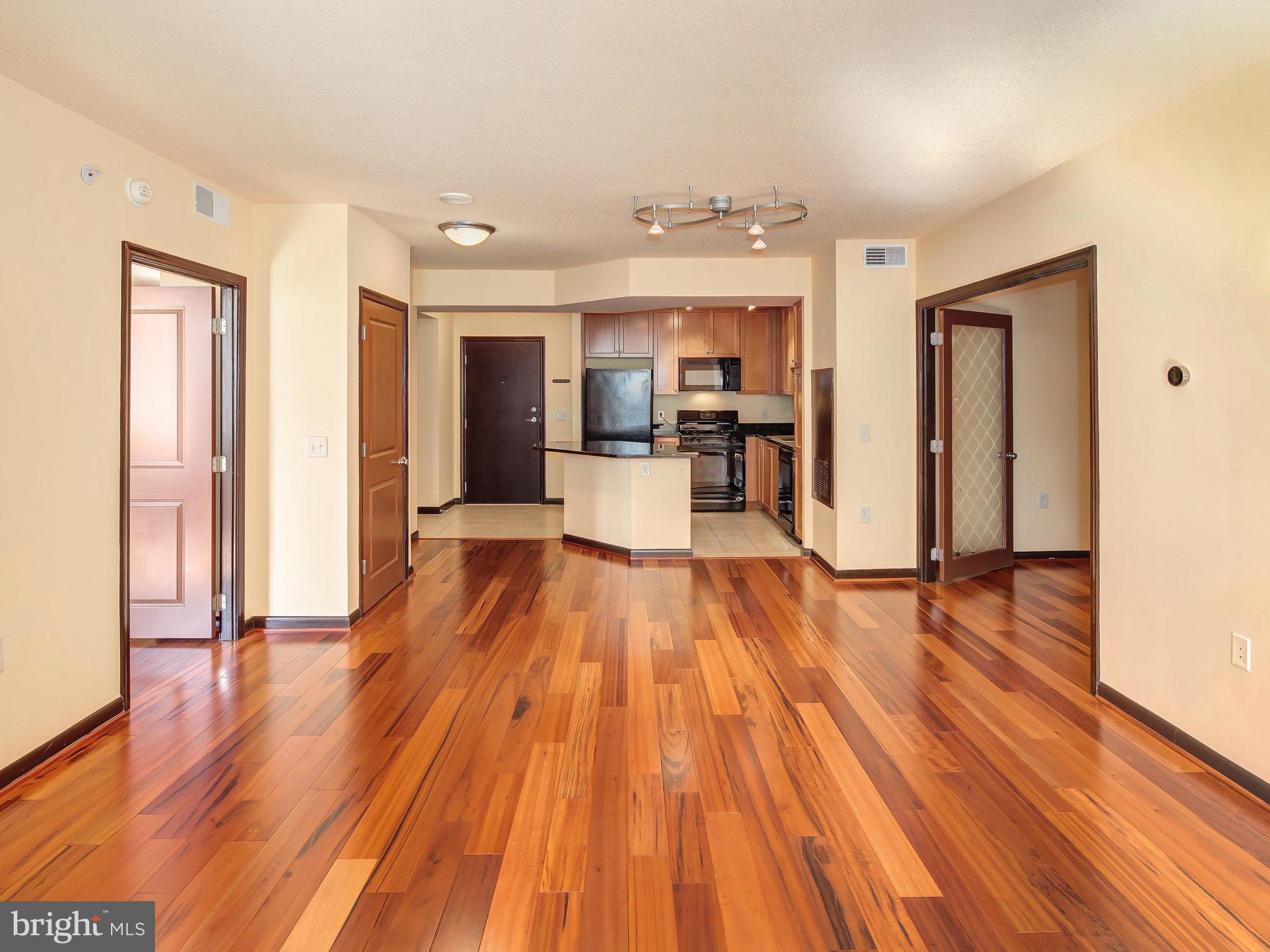 851 North Glebe Road, Unit 921 Arlington, VA 22203 - Photo 4 of 29 a view of a living room with kitchen island wooden floor and stainless steel appliances
