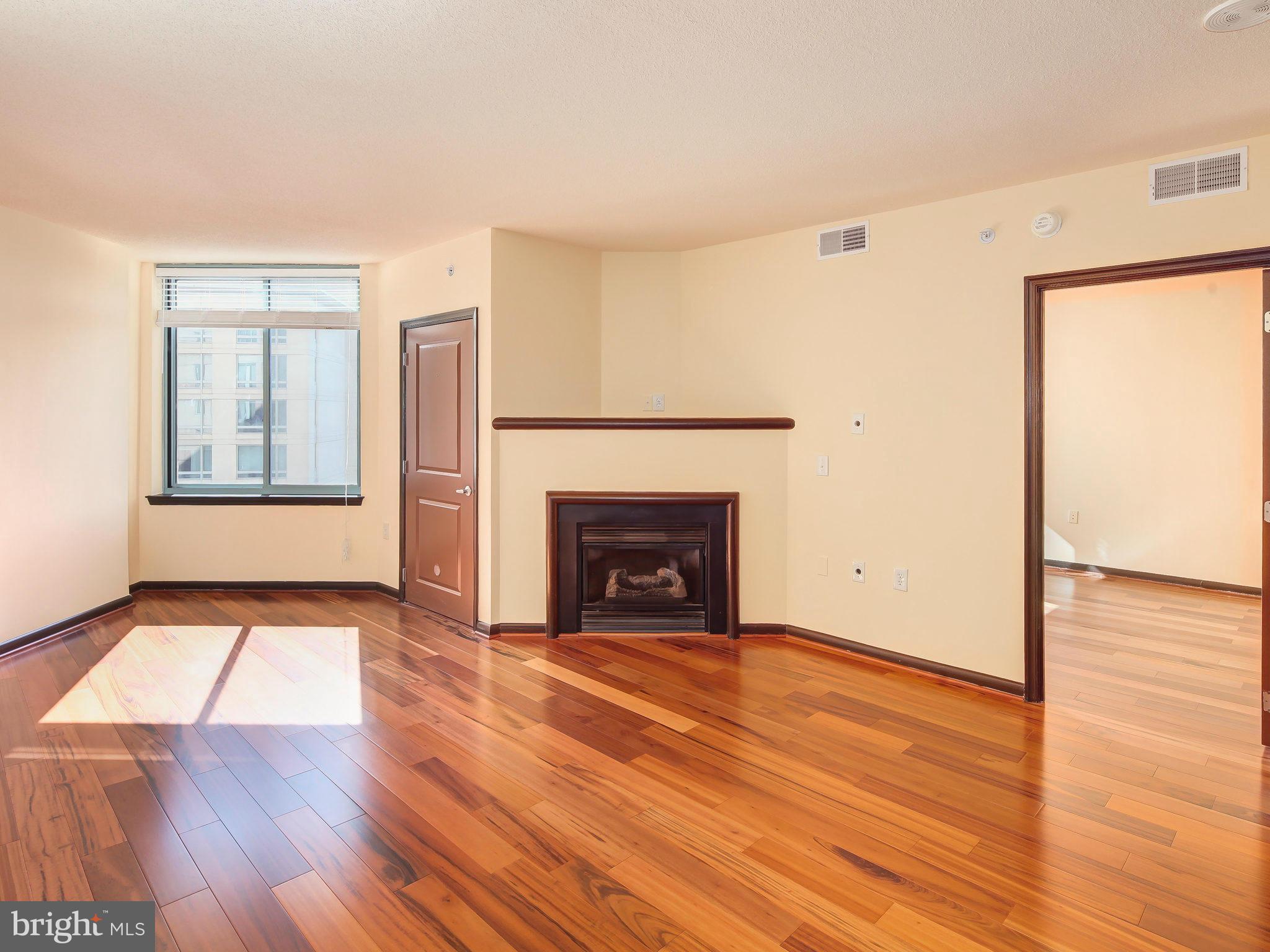 851 North Glebe Road, Unit 921 Arlington, VA 22203 - Photo 8 of 29 a view of an empty room with wooden floor fireplace and a window