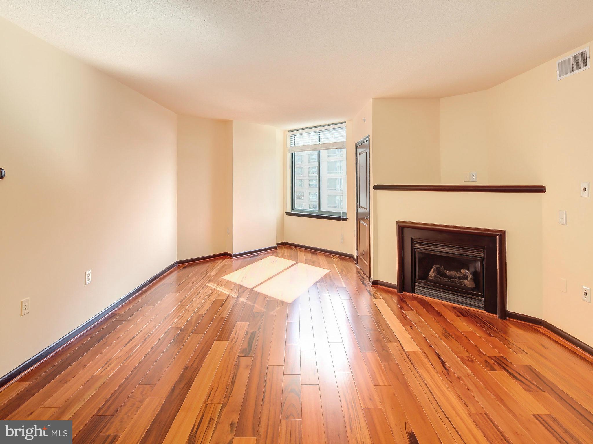 851 North Glebe Road, Unit 921 Arlington, VA 22203 - Photo 9 of 29 a view of an empty room with wooden floor fireplace and a window