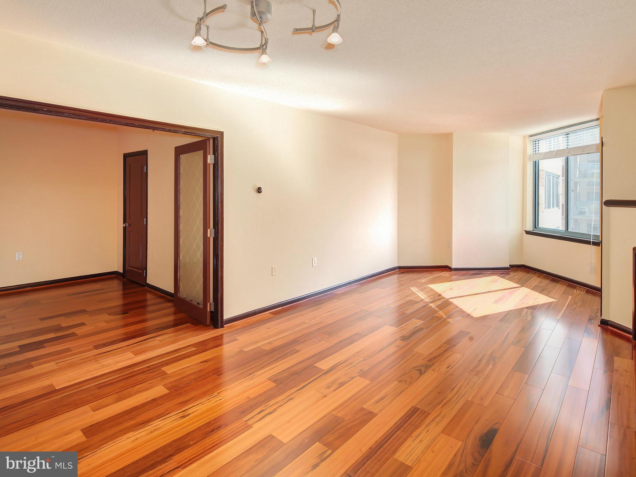 851 North Glebe Road, Unit 921 Arlington, VA 22203 - Photo 10 of 29 an empty room with wooden floor and windows