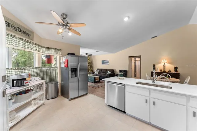 a kitchen with stainless steel appliances granite countertop a sink refrigerator and cabinets